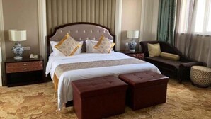 A hotel room with a large bed, two bedside tables, a sofa, and a patterned carpet. - Zhongwei International Holiday Hotel (Fushun)