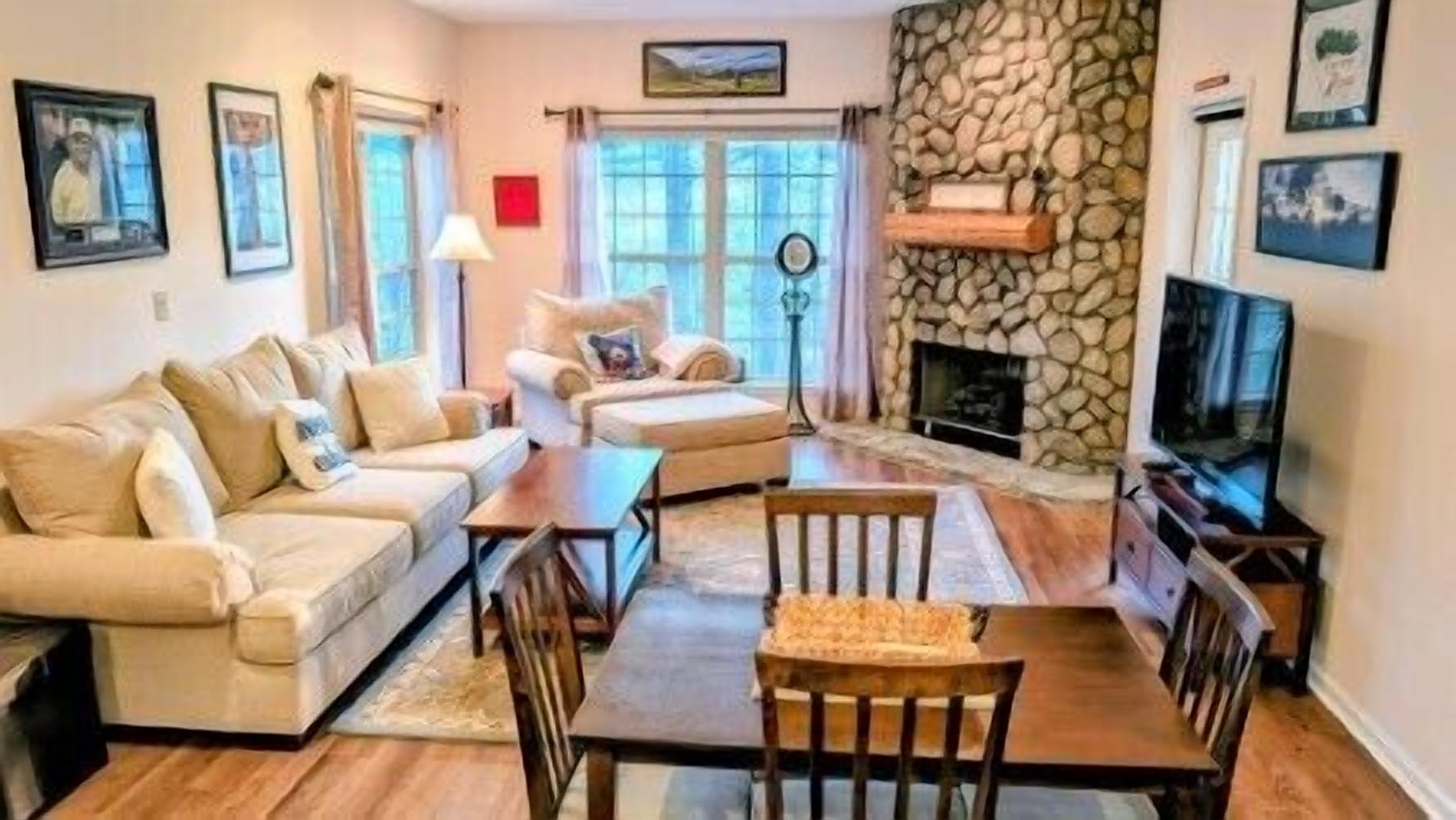 A living room with a sofa set, a coffee table, and a fireplace.
