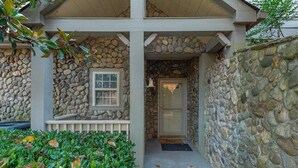 A stone house with a porch, a door, and a window. - Stonecrest 188 at Rumbling Bald (Lake Lure)