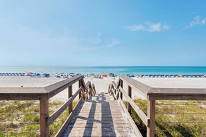 A wooden boardwalk leading to a beach with umbrellas and people. - ★ Clean, Beautiful Beach Retreat ★ w/ Semi-Private Beach Access, Chair/Umbrella (Miramar Beach)