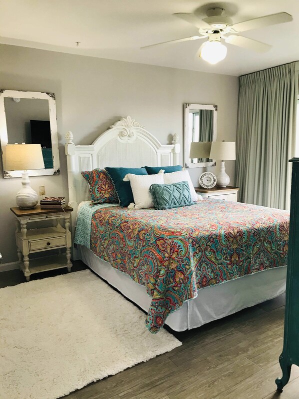 A bedroom with a bed, a nightstand, a mirror, a ceiling fan, and a window with curtains. - ★ Clean, Beautiful Beach Retreat ★ w/ Semi-Private Beach Access, Chair/Umbrella (Miramar Beach)