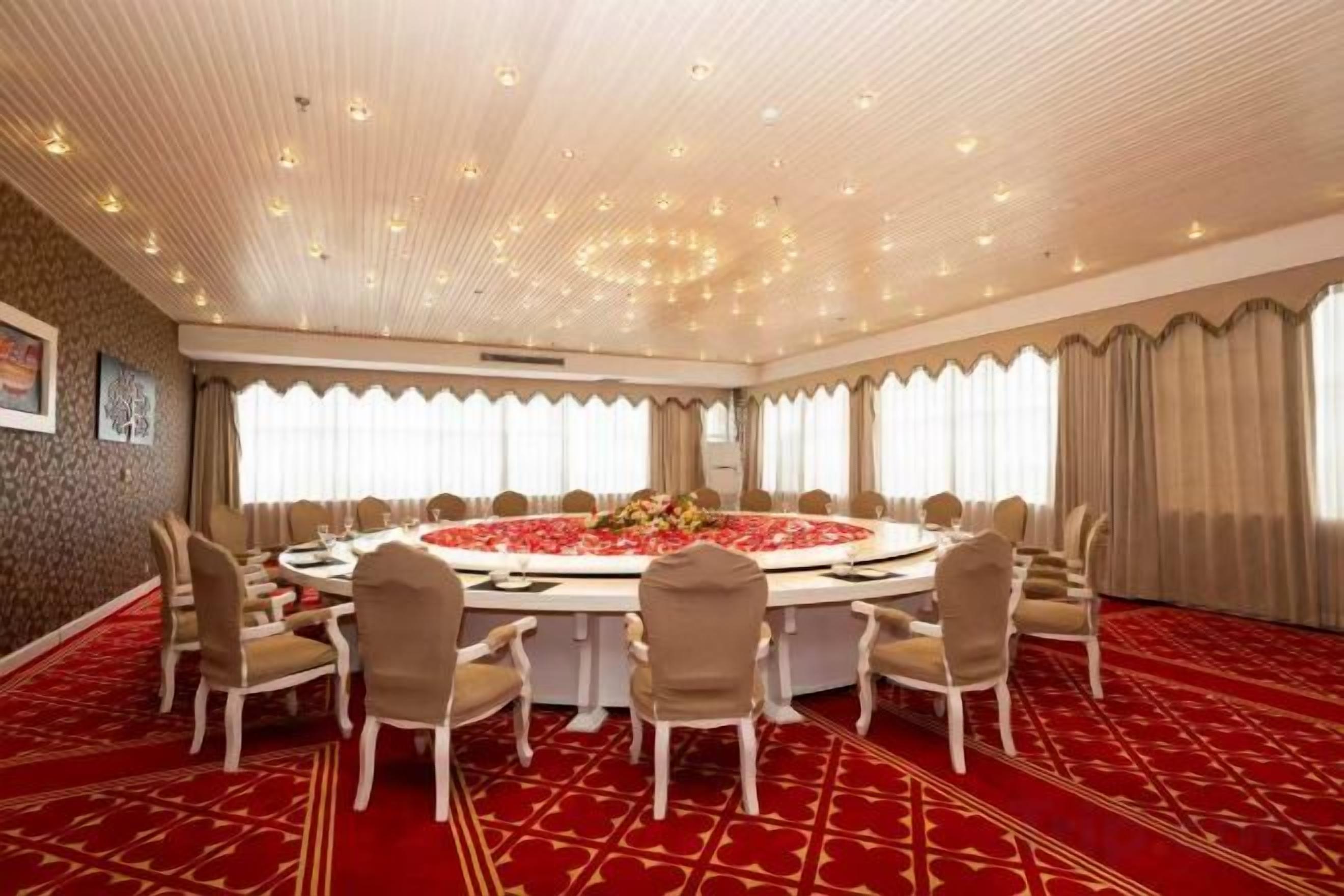 A conference room with a round table, chairs, and a red carpet.