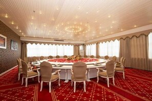 A conference room with a round table, chairs, and a red carpet. - Baoshi International Hotel (Antu)