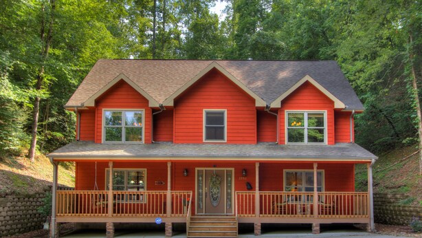 A two-story house with a porch, a front door, and a small front yard.