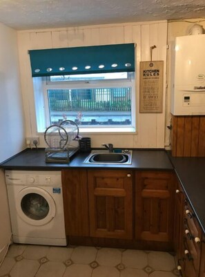 Enjoy cooking in this well-equipped kitchen with a washing machine and sink.