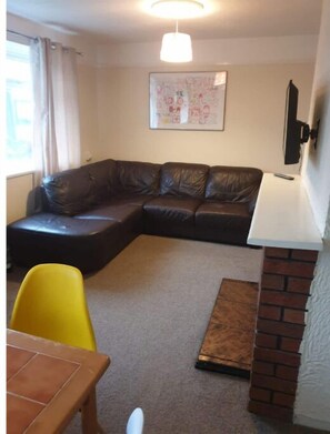 Cozy living space with a sofa, dining area, and artwork on the wall.