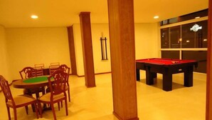 A room with a pool table, a billiards table, and a dining area with chairs and a table. - Hotel Villa Aconchego de Gramado (Gramado)