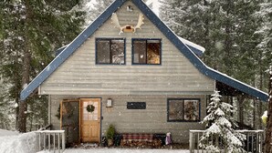 A two-story wooden cabin with a gabled roof, a front porch, and a snow-covered landscape. - Hot tub,pool table,xc/downhill ski,near-Stevens Pass,Leavenworth,Lake Wenatchee (Leavenworth)