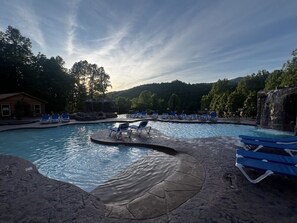 Une piscine dotée de chaises longues et agrémentée d’une cascade.