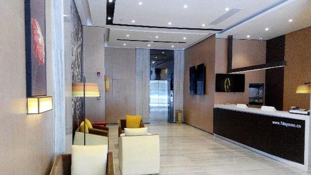 A modern hotel lobby with a reception desk, seating area, and a large window. - Iu Hotel Guangzhou Jingxi Nanfang Hospital Station (Guangzhou)