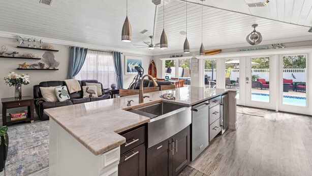 A spacious kitchen with a large island, dark cabinetry, and pendant lighting.