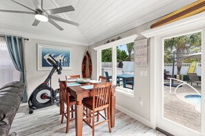 Enjoy meals in the dining area with a table and chairs, overlooking the pool and outdoor patio.