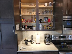 Enjoy cooking in this well-equipped kitchen with a stainless steel range hood, oven, and coffee maker.