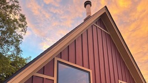 Un edificio de madera rojo con ventanas grandes y una chimenea.