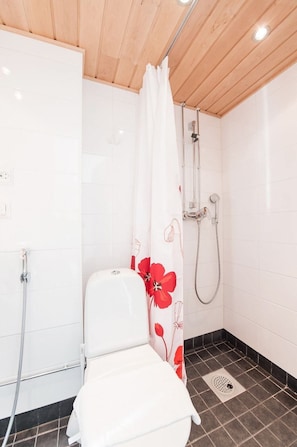 A small, clean bathroom with white tiles, a shower, and a toilet. - Forenom Aparthotel Helsinki Kamppi (Helsinki)