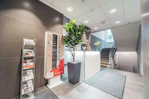 A reception area with a vending machine, a plant, and a staircase. - Forenom Aparthotel Helsinki Kamppi (Helsinki)