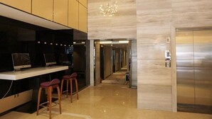 A modern lobby with a reception desk, bar stools, a chandelier, and an elevator. - Lavande Hotels Nanjing Xinjiekou Zhangfuyuan Metro Station (Nanjing)