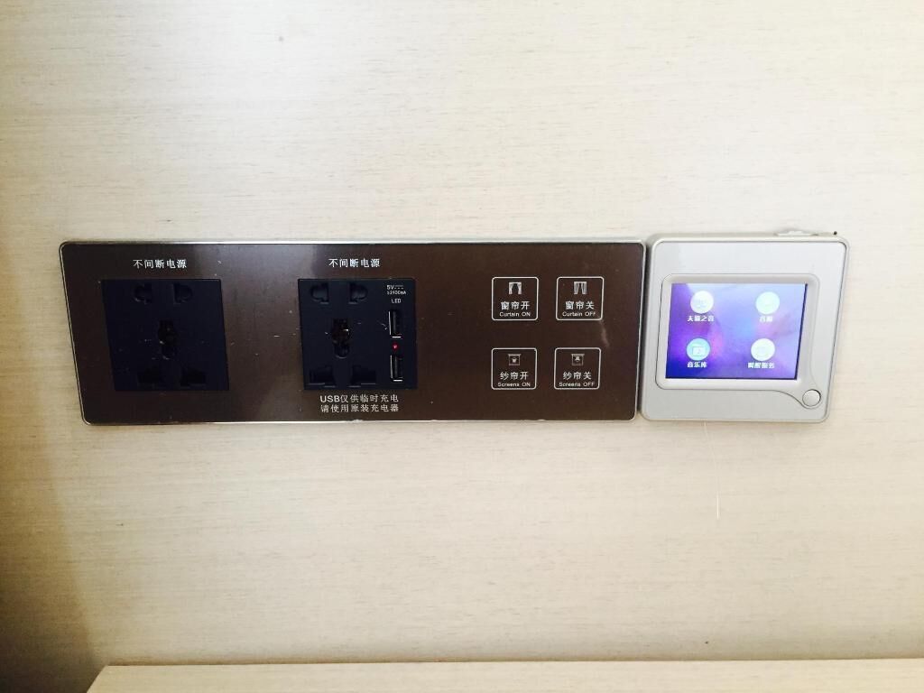 Un panel eléctrico de pared con puertos USB y un tablero de control con varios interruptores.