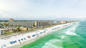 A coastal hotel with multiple buildings, a beach with umbrellas, and ocean views. - Beachfront Condo, Gulf Views, Sunset Balcony, Okaloosa Island (Fort Walton Beach)