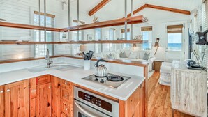 A modern kitchen with wooden cabinetry, a built-in oven, and a large island with a kettle. - Seaside's Chic Gulf-Front Retreat, Renovated with Elegant Design, Ocean Views, and Jacuzzi! (Santa Rosa Beach)