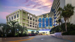 A hotel with a modern facade, multiple floors, and a prominent sign reading "CORAL BEACH RESORT". - Partial Ocean Views in South Myrtle Beach - Full Access to Amenities! (Myrtle Beach)