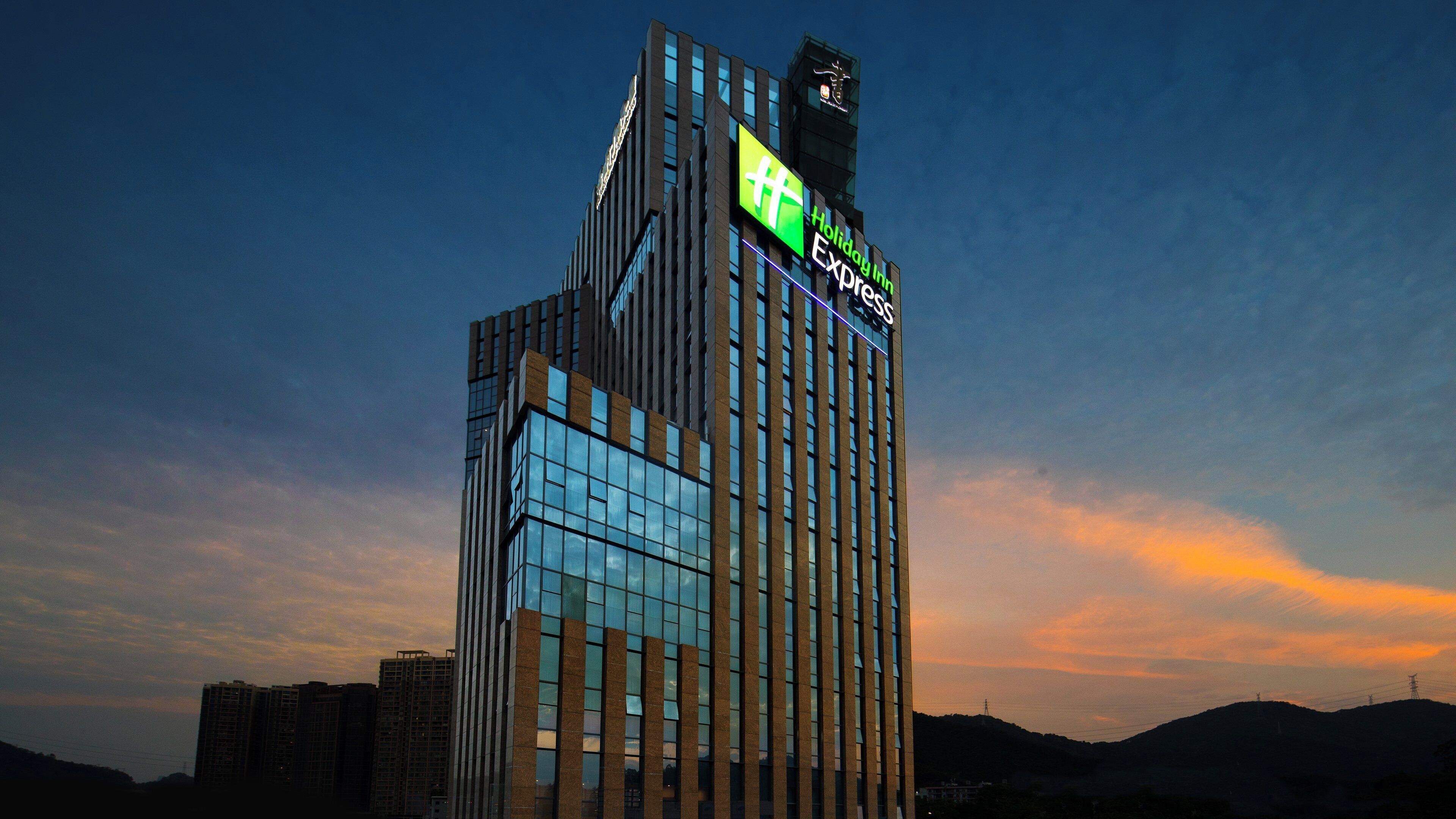 Een hoog gebouw met een opvallend bord met daarop Holiday Inn Express.