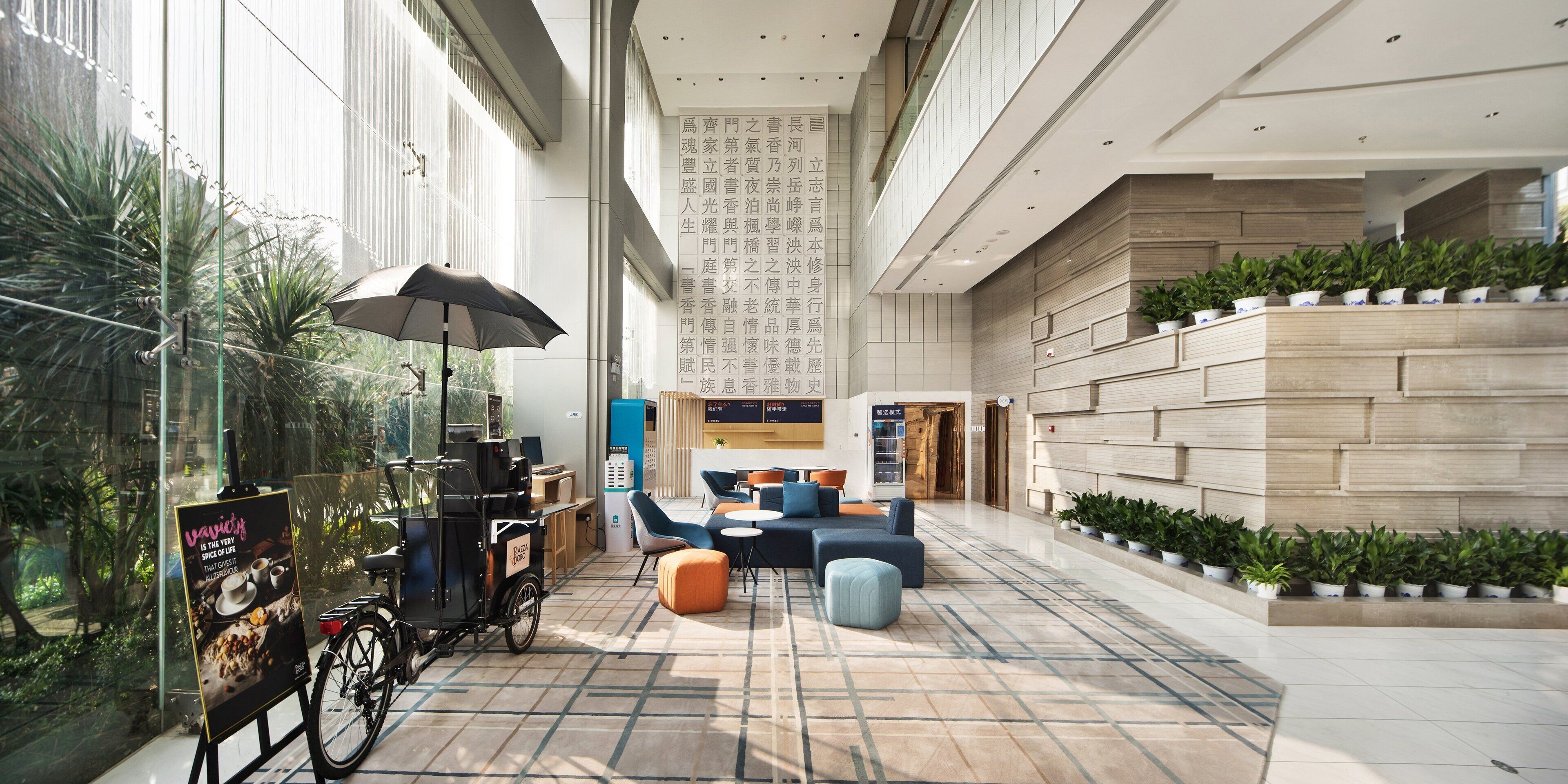 A spacious indoor area with seating arrangements, a bicycle, and a vending machine.