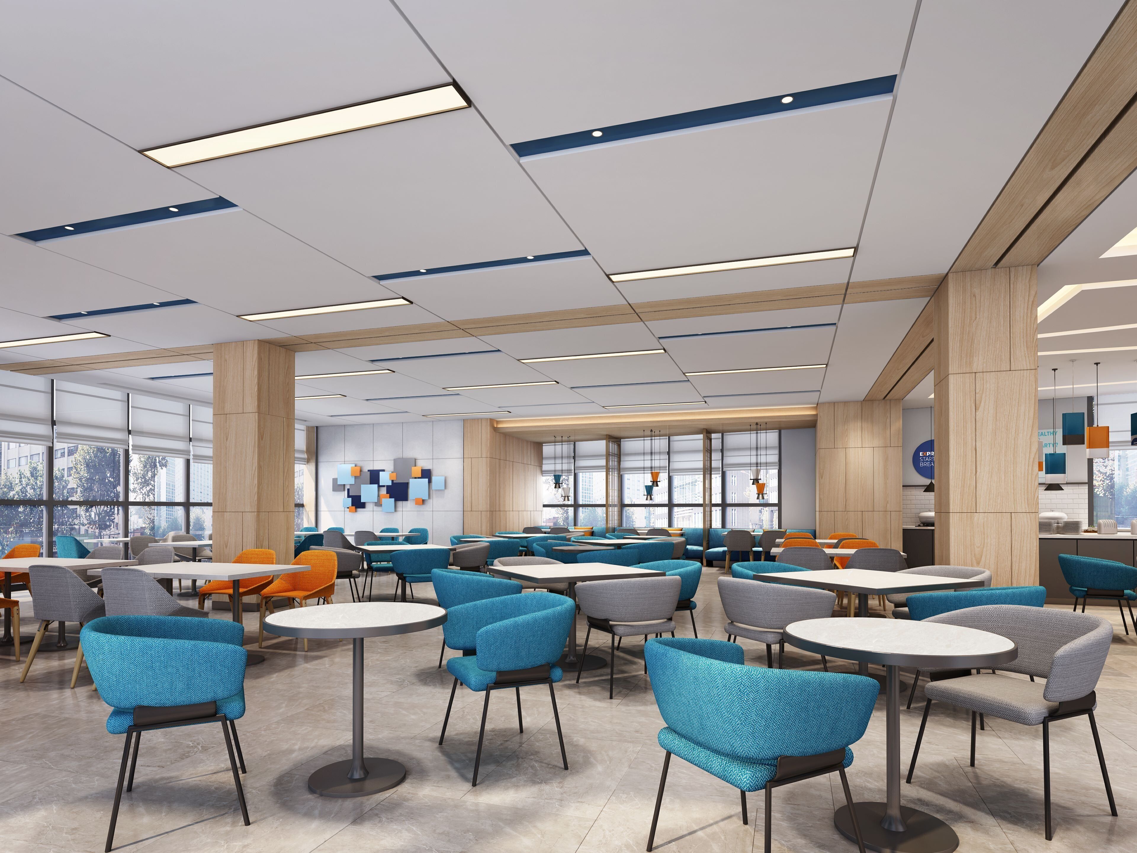 A modern indoor space with multiple seating areas, including round tables and chairs, and large windows providing natural light.
