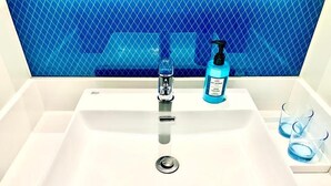 A bathroom sink with a blue tiled backsplash, a faucet, a soap dispenser, and two glasses. - Holiday Inn Express Shenzhen North Station by IHG (Shenzhen)