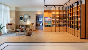 A modern living room with a wooden floor, a bookshelf filled with various items, and a seating area with chairs and a table. - Staybridge Suites Dubai Financial Centre by IHG (Dubai)