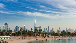 A beach with palm trees and a city skyline in the background. - Staybridge Suites Dubai Financial Centre by IHG (Dubai)
