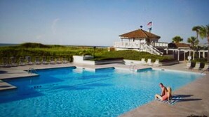 A swimming pool with a gazebo and a flag, surrounded by greenery and a clear sky. - Hidden gem in the heart of Ocean Creek (Myrtle Beach)