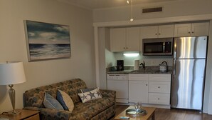 A bedroom with a bed, a sofa, a coffee table, and a kitchenette with a microwave and refrigerator. - Hidden gem in the heart of Ocean Creek (Myrtle Beach)