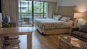 A hotel room with a bed, a desk with a chair, a small table with a lamp, and a sofa. - Hidden gem in the heart of Ocean Creek (Myrtle Beach)