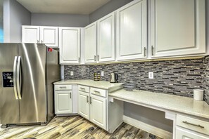Enjoy cooking in this well-equipped kitchen with a stainless steel refrigerator, kettle, and coffee maker.