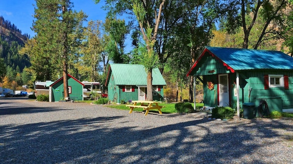 Un terrain de camping avec des cabanes en bois, une table de pique-nique et des emplacements pour camping-cars.