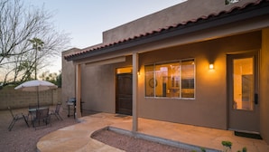 Ein modernes Haus mit Terrasse, Essbereich und Garage.