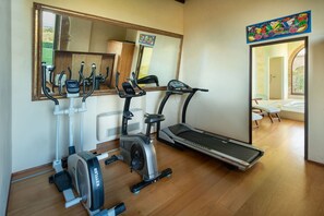 A home gym with a treadmill, stationary bike, and elliptical machine.