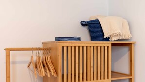 A wooden storage unit with a hanging rack and shelves.