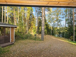 A cabin with a wooden deck and a view of a forested area.