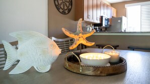 Une table à manger décorée avec un poisson, une étoile de mer et des bougies.