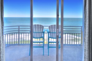 Enjoy the ocean view from this balcony with two Adirondack chairs.