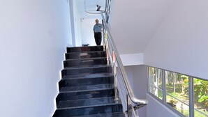 Uma escada com corrimãos de metal e uma pessoa descendo.