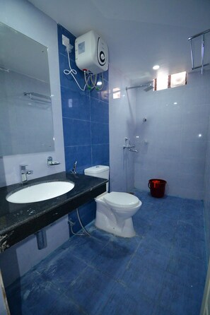 Une salle de bain avec un lavabo, des toilettes et une douche.