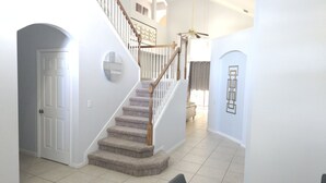A staircase with carpeted steps and wooden railings, leading to an upper floor.