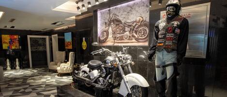 A showroom with a motorcycle and a mannequin dressed in biker gear.
