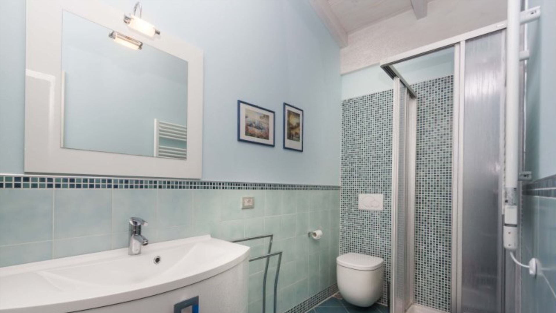 Ein Badezimmer mit Waschbecken, Spiegel und Dusche.