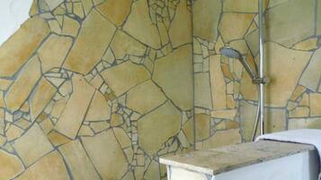 Ein Badezimmer mit Mosaikfliesen, einer Dusche und einem Waschbecken.