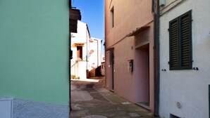 A narrow alleyway between buildings with a manhole cover on the ground. - NEL CUORE DI RIO MARINA (Rio Marina)