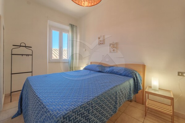 1 dormitorio y tabla de planchar con plancha